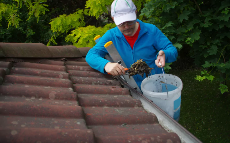 man clearing out gutters